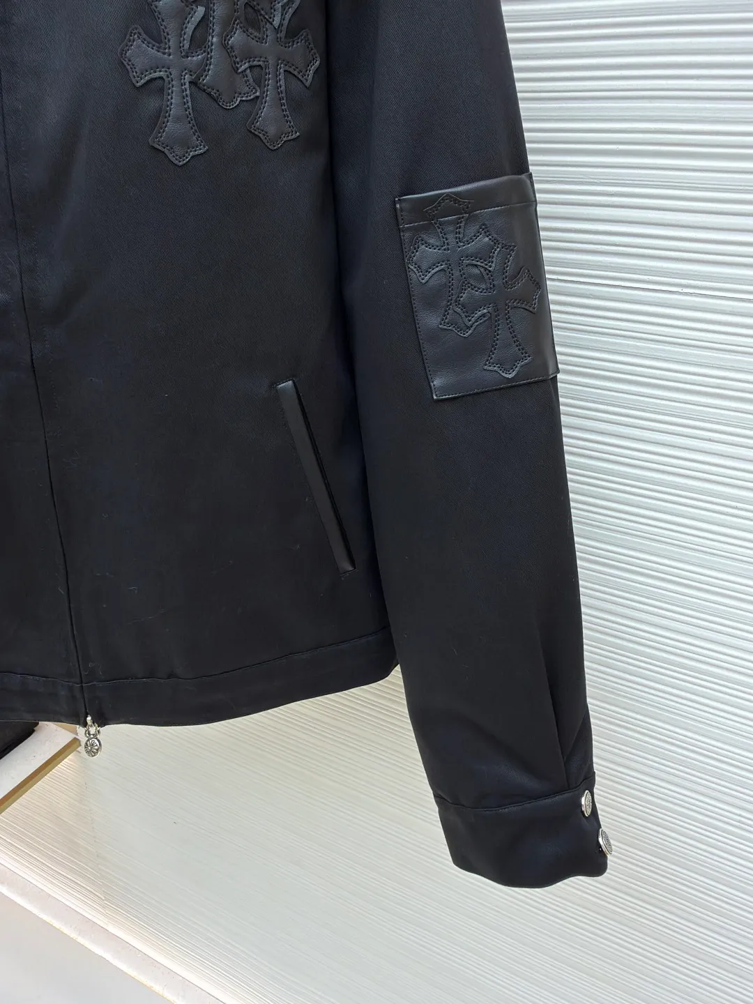 Chrome Hearts solid color logo patch lapel jacket ●Original version: purchased and developed by 13730 ●Item number: 1681764-B75 ●Fabric: leather fabric ●Technology: patch production ●Color: black ●Version: fitted version ●Weight: about 1020 grams ●Size: S-M-L-XL ●Description: Made of high-density matte fabric, treated with anti-wrinkle shaping technology, it has both stiffness and drape texture, smooth touch and not easy to pilling. The body is decorated with the brand's iconic cross embroidery, which is created through three-dimensional quilting embroidery technology. The pattern is full of layers and clear texture, which is both recognizable and refined. The cuffs are spliced ​​with leather labels and fixed by heat-pressing lamination technology to enhance texture and durability. The version is loosely cut, with metal zipper + decorative pendant, which makes it easy to put on and take off and enhances the details; the cuff button adjustment design adapts to different arm circumferences, and the hem is naturally edged to ensure a neat fit. The stitching of the whole garment is neat, with no exposed threads at the splicing points. The size is measured manually (an error of 1-3CM is normal). The craftsmanship balances the dark style and practical wearability. It is a single product with both styling and practicality. The overall wiring is straight and delicate, the fabric is comfortable and soft, and the color is consistent without color difference. It can be matched with the same style to create a fashionable look and control various occasions. Customized accessories, complete with three standards, same style for men and women!